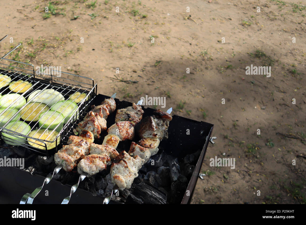 Appetizing grilled meat and vegetables roasting on the old grill outdoors Stock Photo