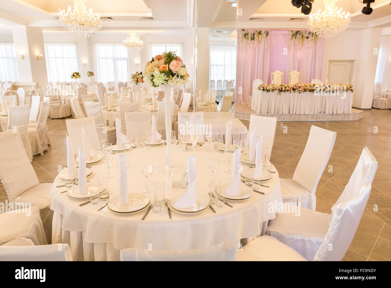 interior design, engagement, flower arrangement concept. there is a restaurant hall prepared for wedding day of two lovers, all space is decorated in  Stock Photo