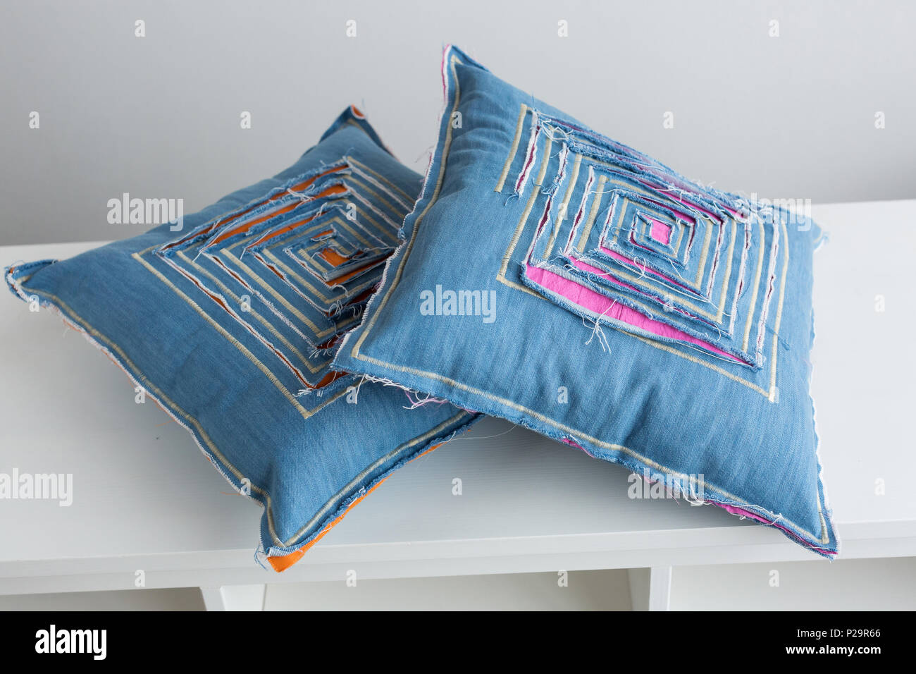 handmade, interior design, decoration elements concept. there is sinple but original pillowcases that was sewed of jeans fabric, each one has cuts tha Stock Photo