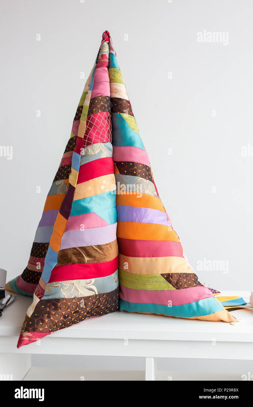 handmade, interior, decoration concept. there is a tall and soft construction in form of christmas tree but made of bright wonderful blanket sewd of d Stock Photo