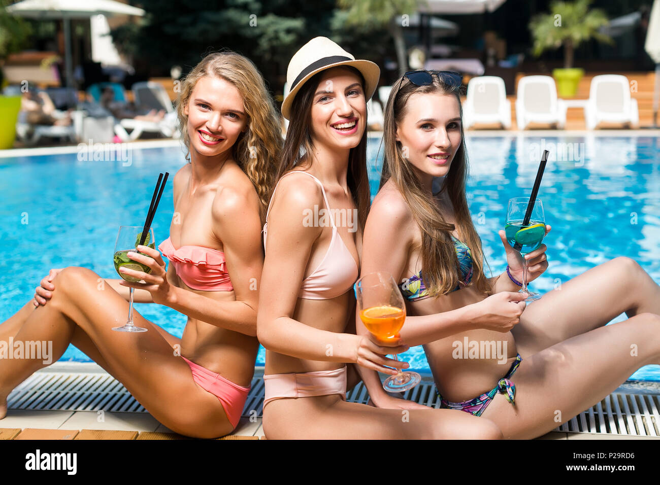 frienship, communication, summer concept. there is a company of girlfriens, they are having sunbathes and and drinking cocktails chatting together, th Stock Photo