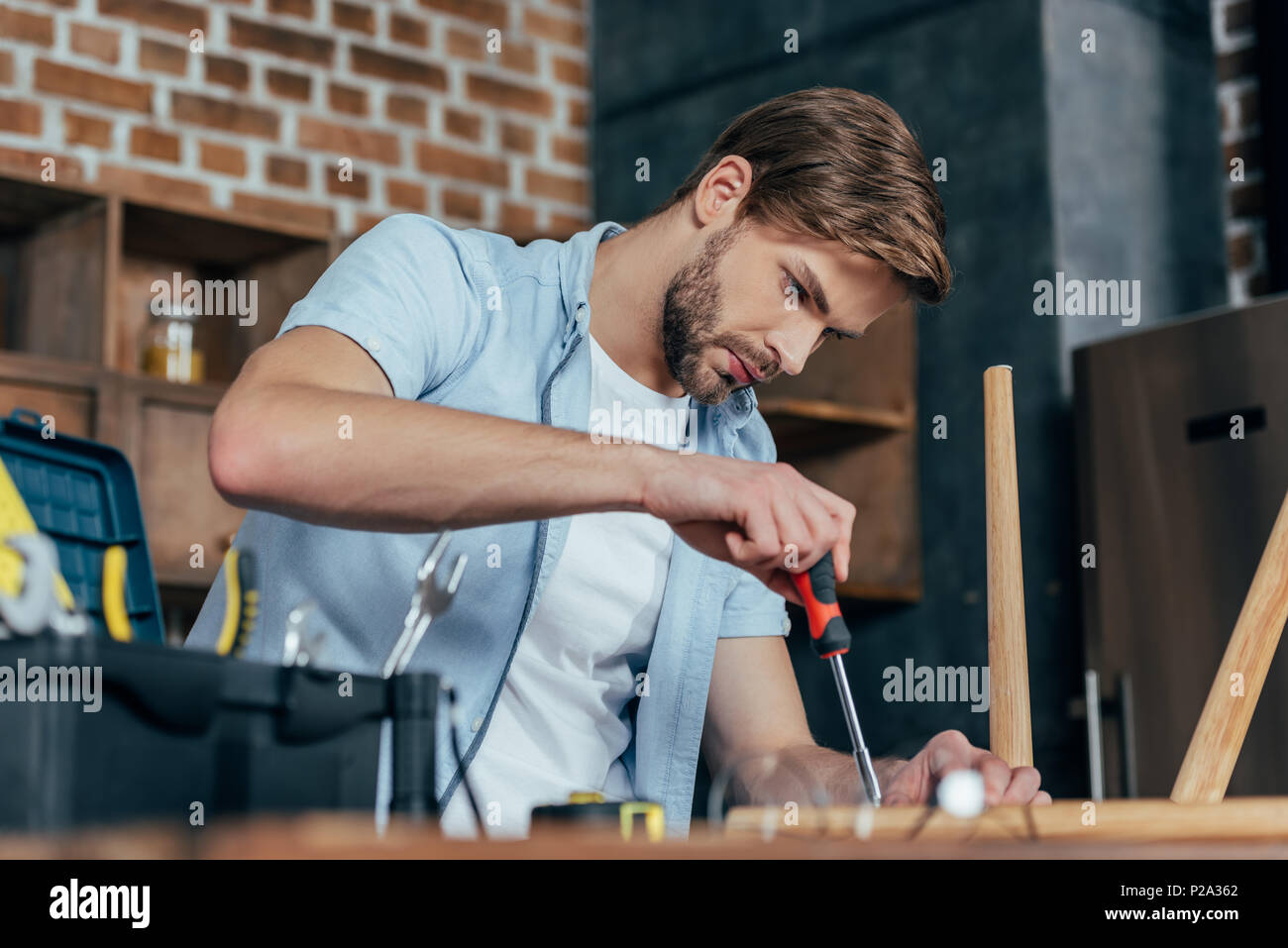 Men Fixing Tools focused young man repairing stool with screwdriver Stock Photo - Alamy