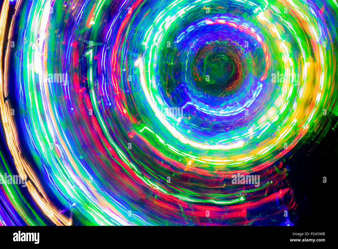 The round of blurred lines of color lights on dark background. Colorful lights blurred by motion. Stock Photo