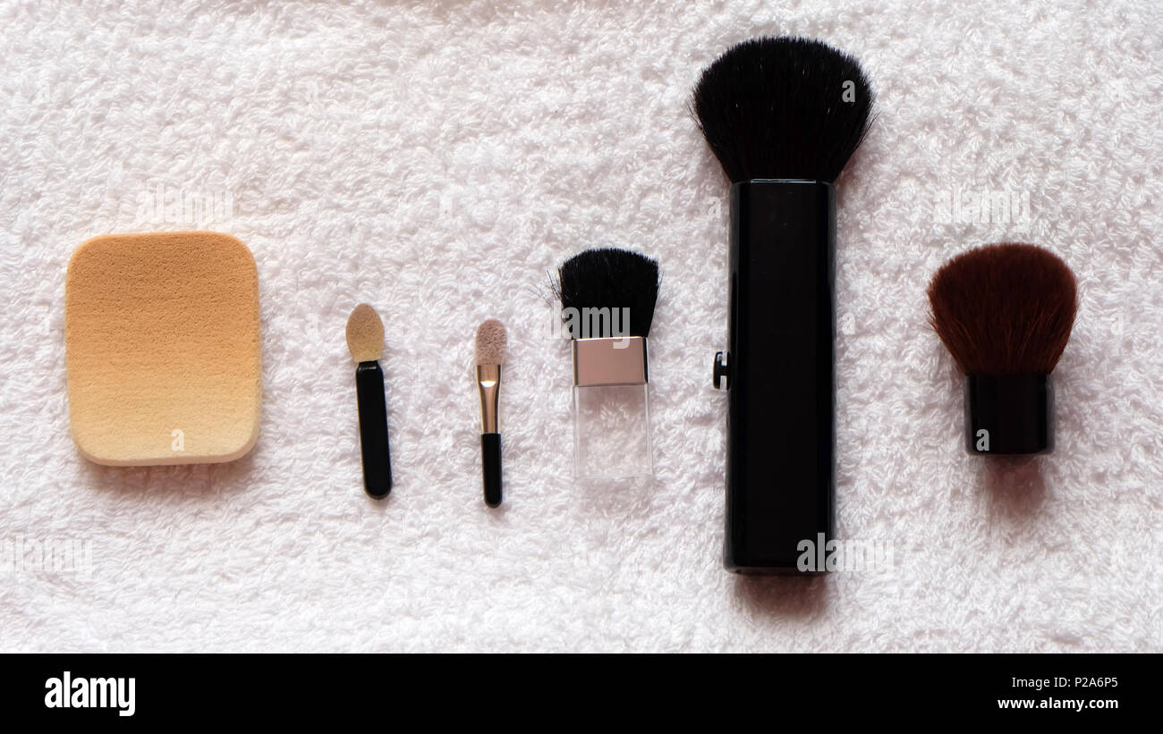 Make up brushes and sponge arranged on a white towel Stock Photo