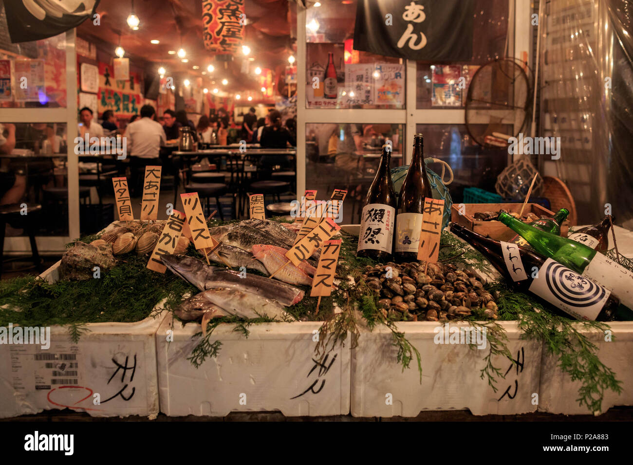 Osaka, Japan June 30, 2017 Fresh seafood and sake bottles in front