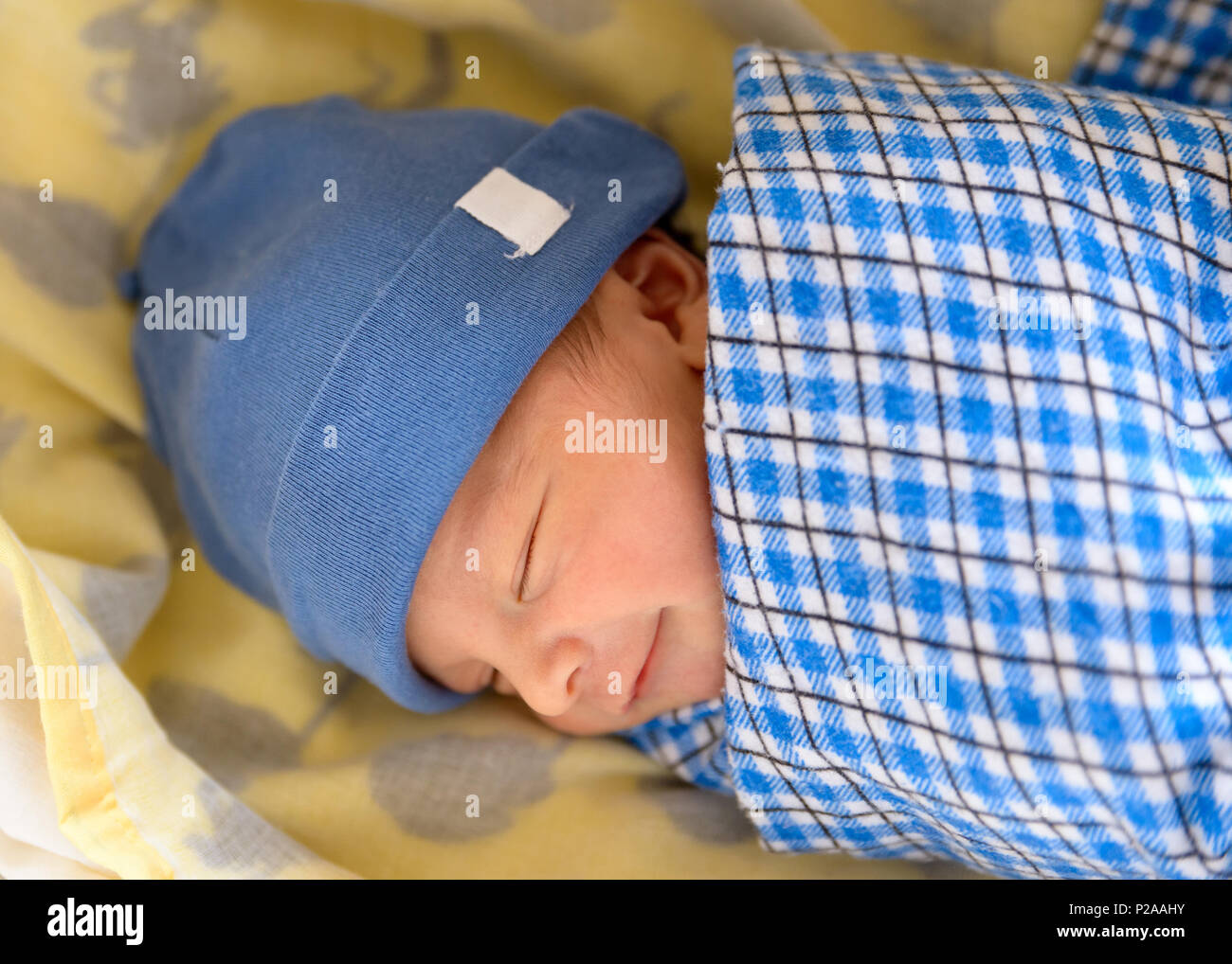 Cute Eurasian newborn baby smiling in his sleep Stock Photo