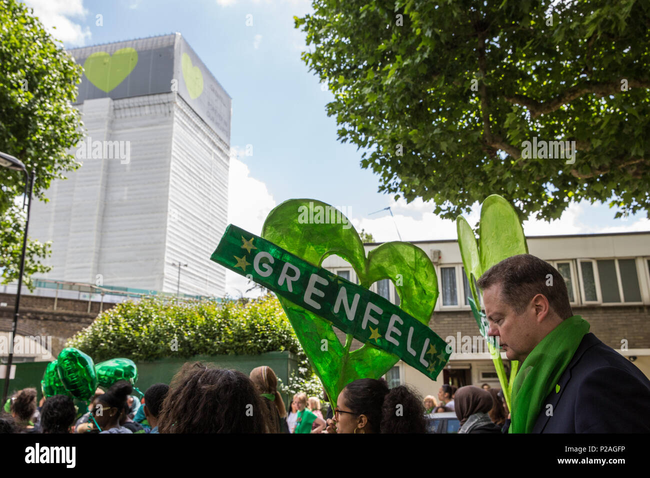 London, UK. 14th June, 2018. Members of the local community, faith leaders, politicians and wellwishers pass the Grenfell Tower, now covered, as they take part in a silent procession from St Helen's Church to the Wall of Truth to mark the first anniversary of the Grenfell Tower Fire. Credit: Mark Kerrison/Alamy Live News Stock Photo