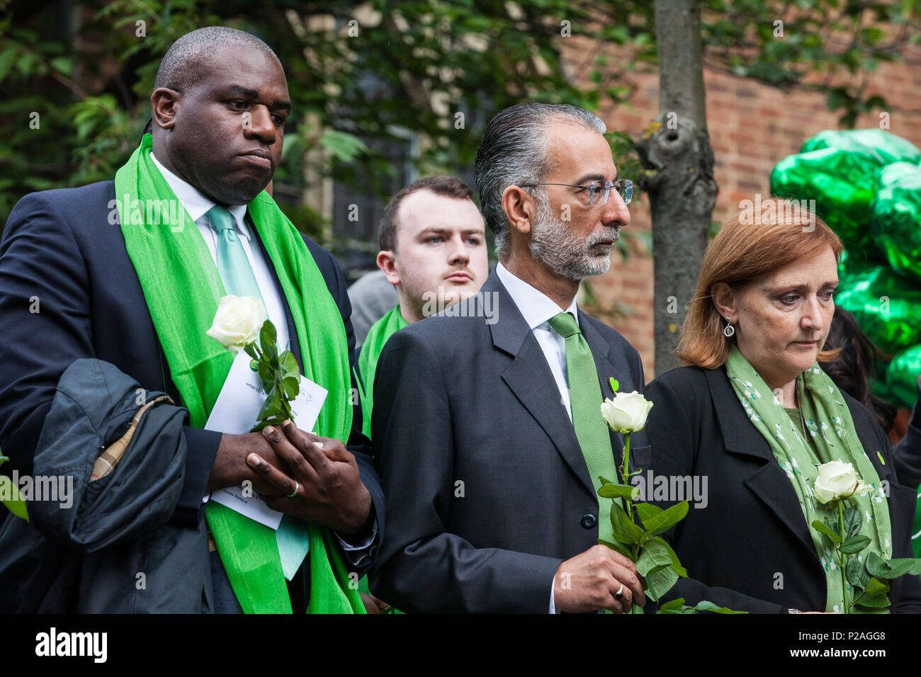London, UK. 14th June, 2018. Faith leaders and politicians, including David Lammy MP (l) and Emma Dent Coad MP (r), hold flowers outside St Helen's Church before doves are released to mark the first anniversary of the Grenfell Tower Fire. Stock Photo