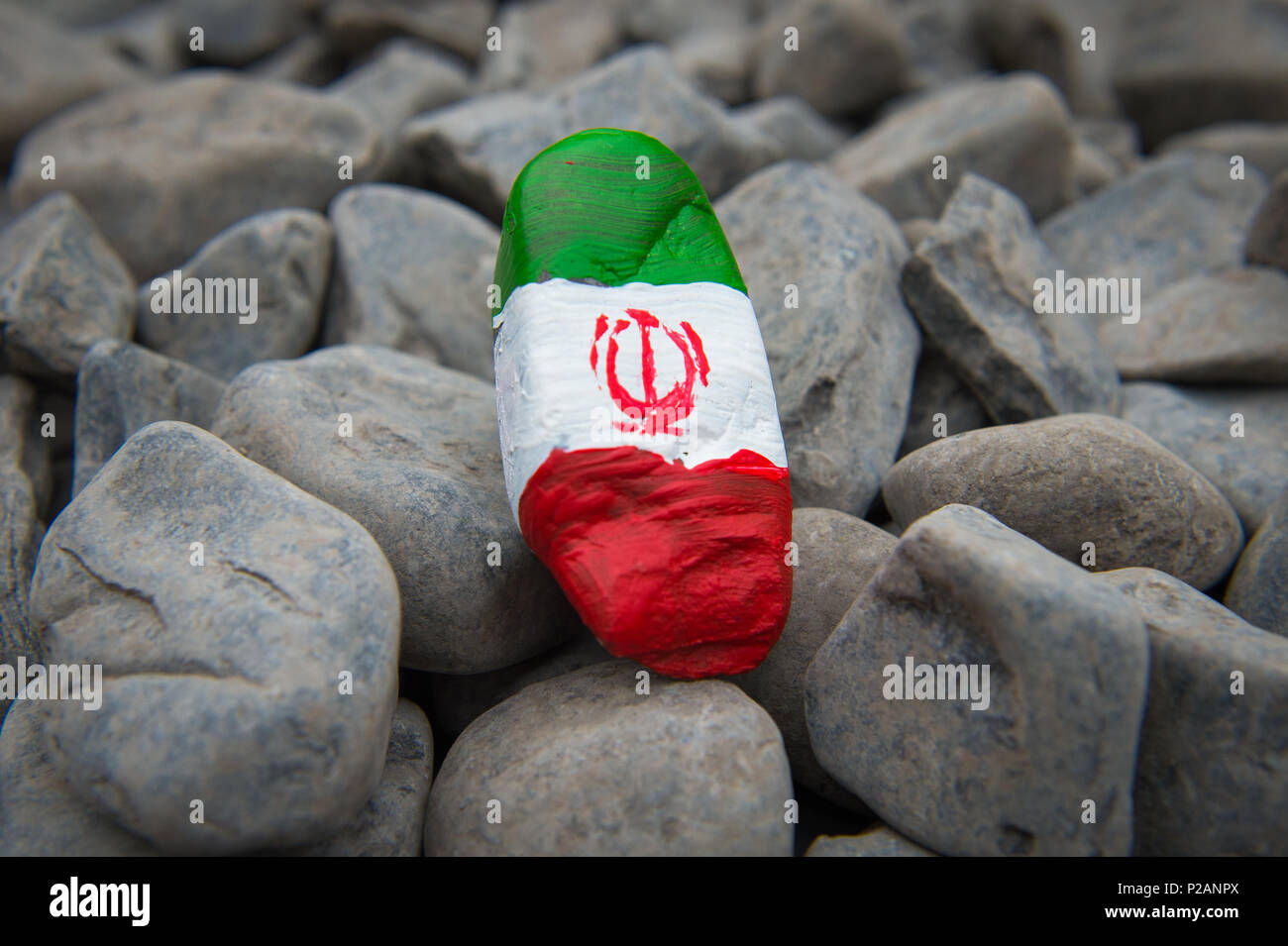 A stone painted by three year old Luke Wilkinson of Mossley, Greater Manchester, England for a nursery project celebrating the FIFA World Cup in Russia. The stone is painted to represent the flag of Iran. Stock Photo