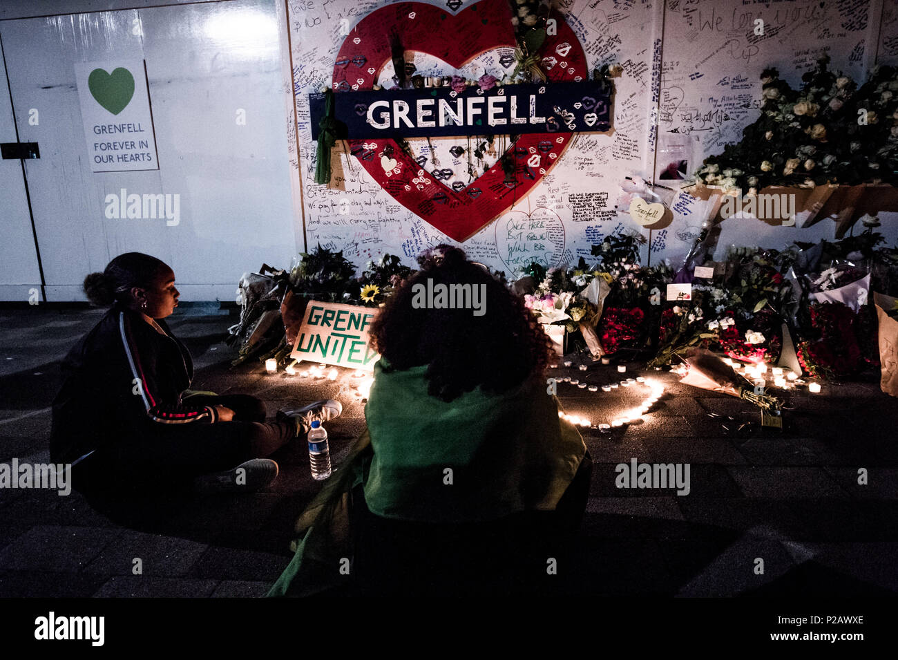 London, UK. 14th June, 2018. A woman seen standing in front of the flowers memorial at the foot of the Grenfell Tower.On the first anniversary of the Grenfell Tower fire, which killed 72 people, the area around the tower has been filled with flowers, candles and messages to remember those who lost their lives. Credit: Brais G. Rouco/SOPA Images/ZUMA Wire/Alamy Live News Stock Photo