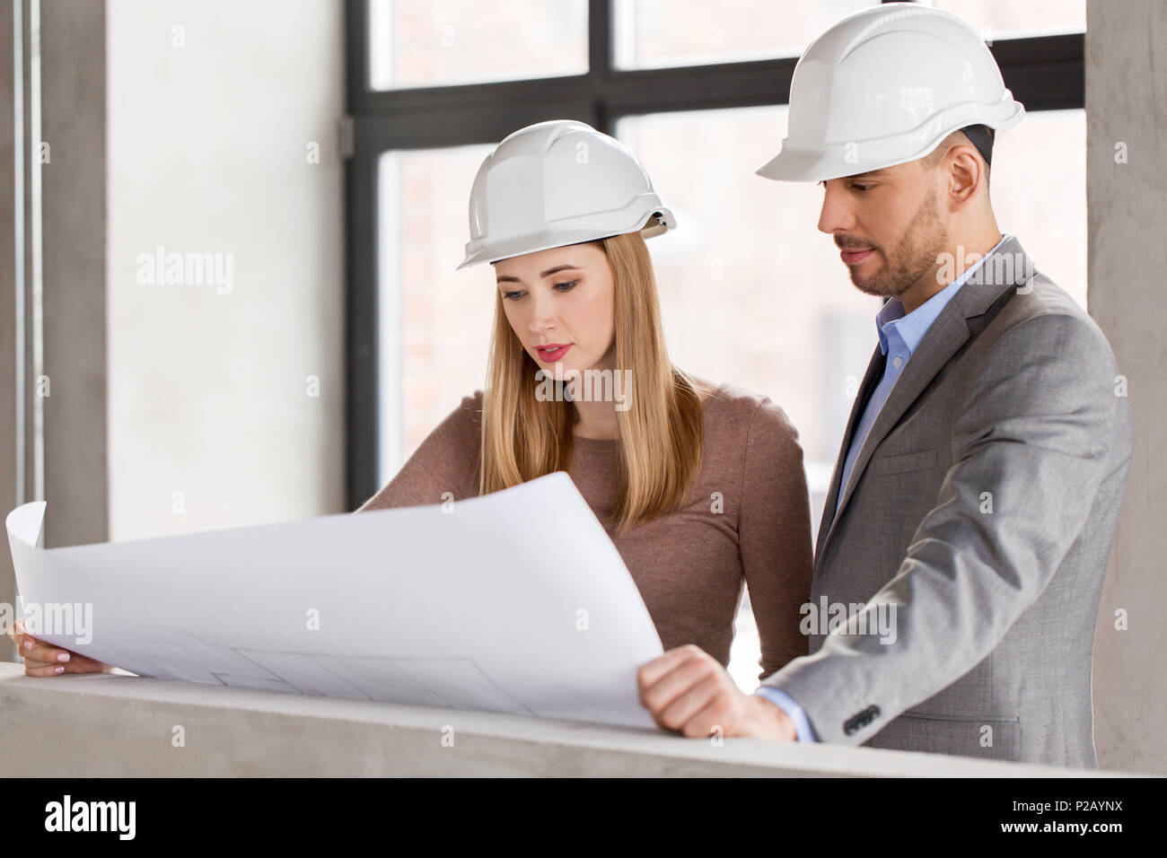 architects with blueprint and helmets at office Stock Photo