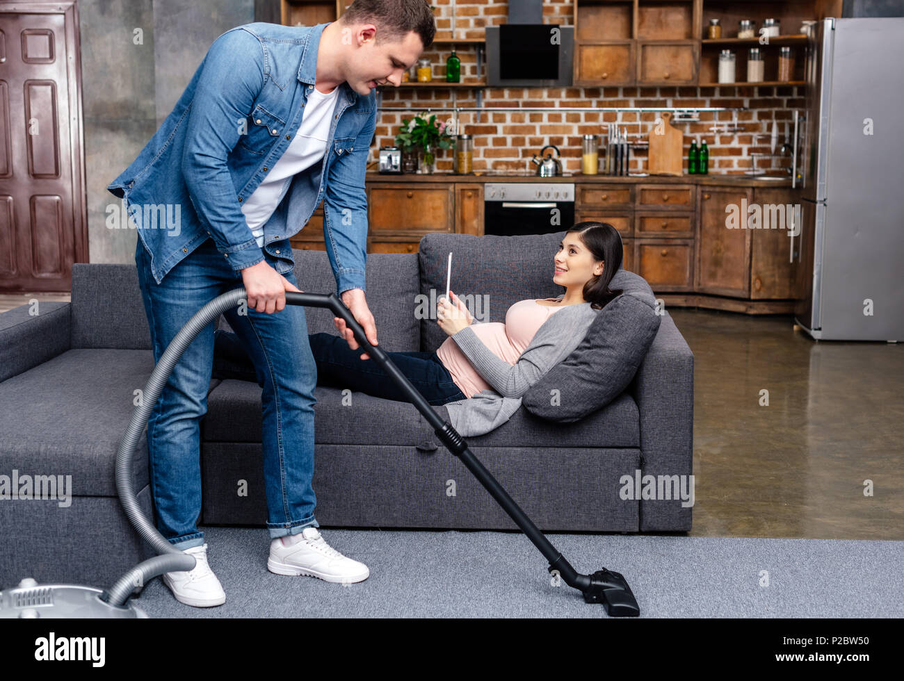 Man lying sofa cleaning woman hires stock photography and images Alamy