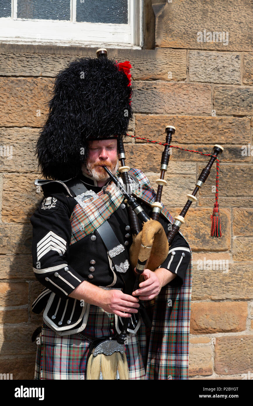 Scotsman in his 40s dressed in tartan and kilt playing the bagpipes, Edinburgh, Scotland UK Stock Photo
