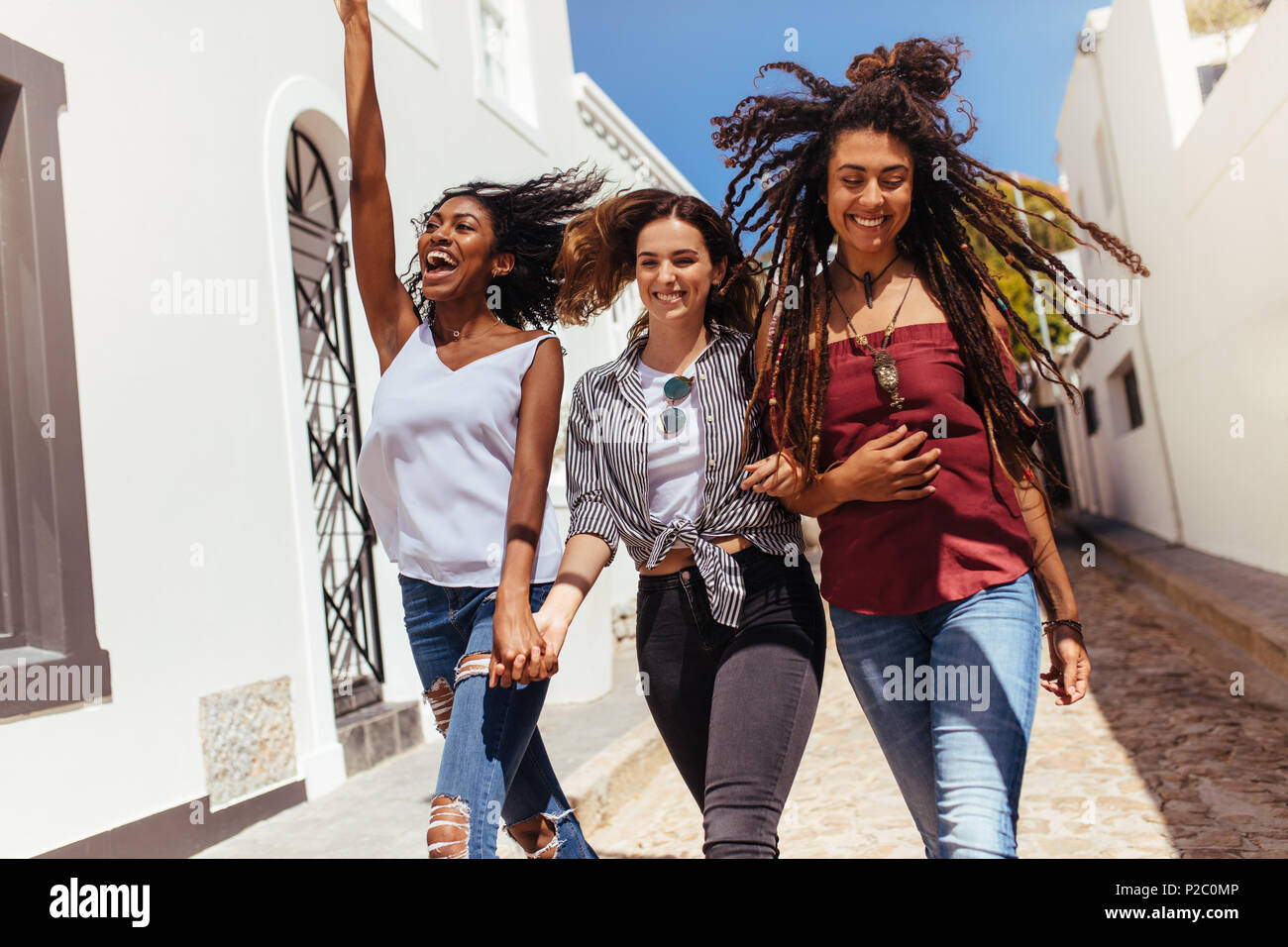 Three happy looking women walking on street wearing fashionable