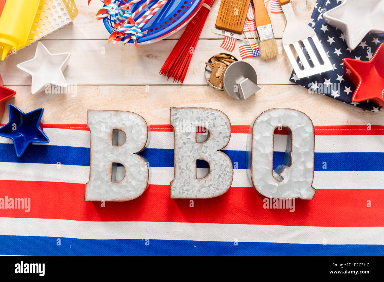 Metal BBQ sign with BBQ cooking tools on a wood background Stock Photo