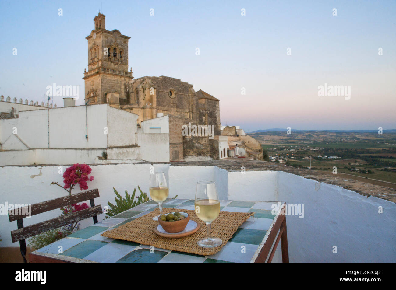 White wine in two Glases and olives on a table on top of the Hotel La Casa Grande with view towards the church of San Pedro, in Stock Photo