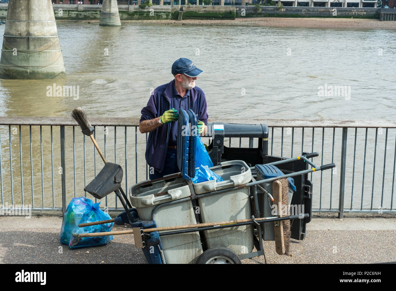 Street cleaner by the Millenium bridge on Bankside, Southwark, London, UK. Stock Photo