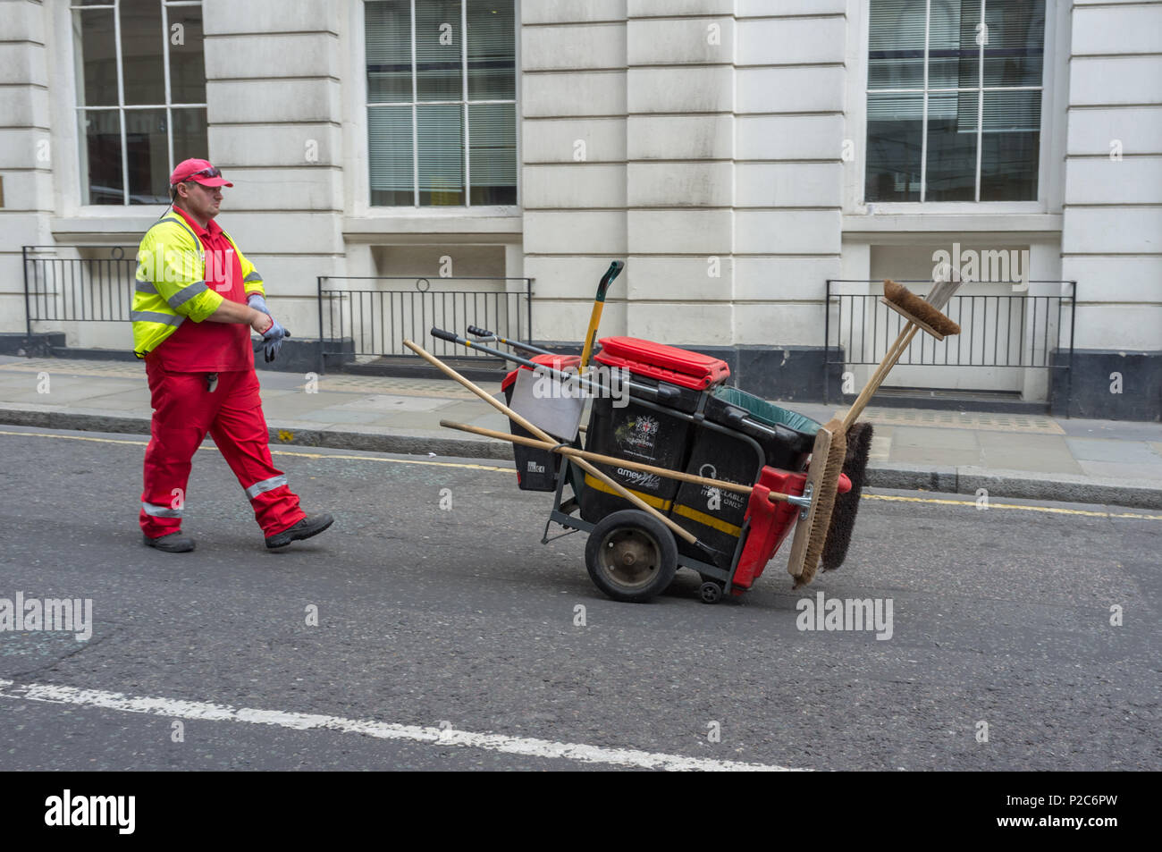 Street cleaner dressed in high visibility clothing in the City of London, England, UK. Stock Photo