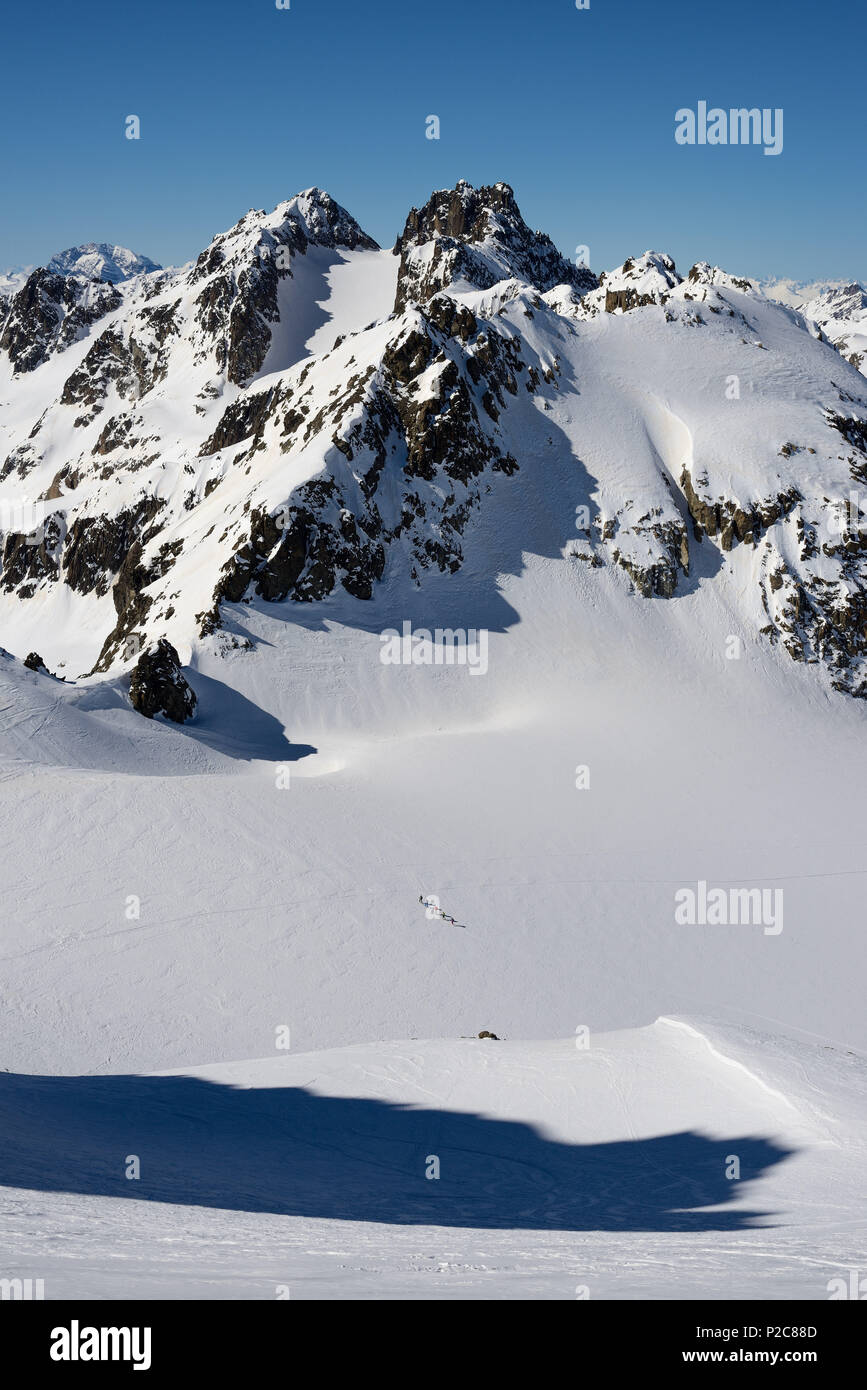 A group of ski-tourers ascending on the Grialetsch-Glacier, above them Piz Vadret and in the background left hand Piz Ela, Griso Stock Photo