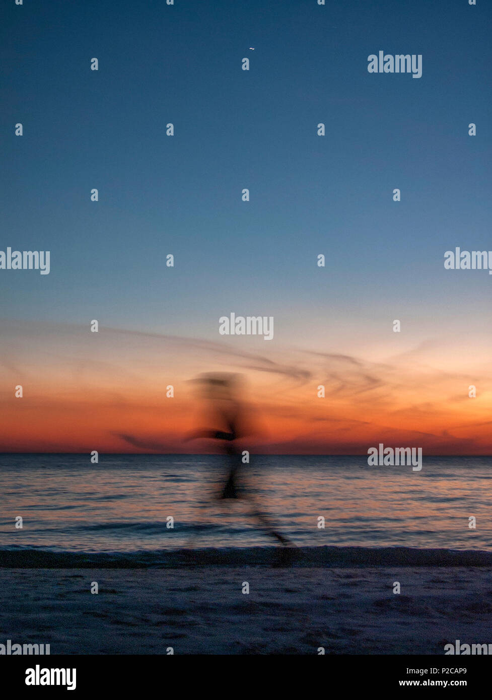 Redington Beach, Florida, USA,  Saturday  01/10/2016. slow shutter, as a jogger passes along the Beach © Peter SPURRIER Stock Photo