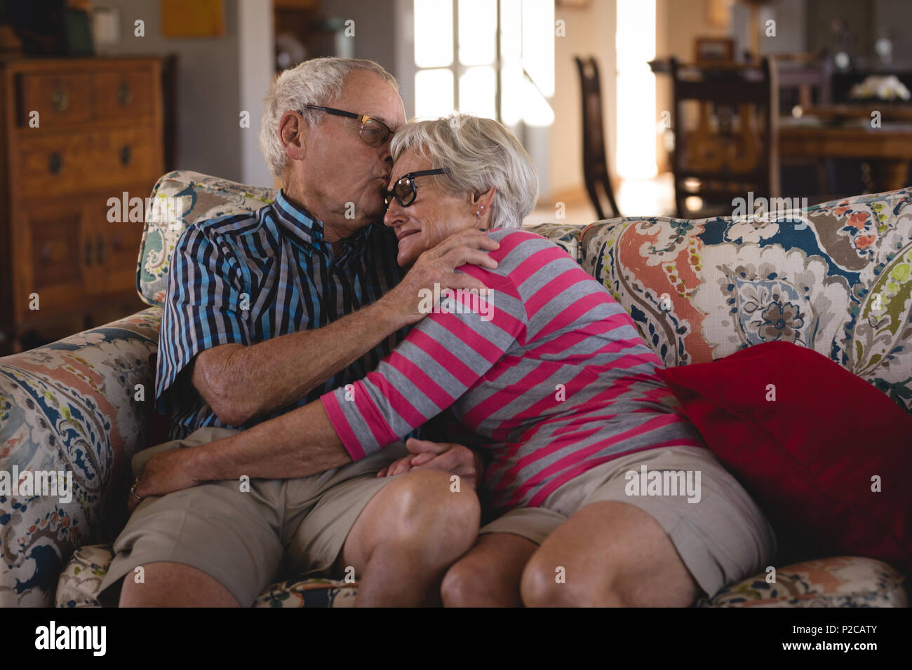 Romanced senior couple sitting on sofa Stock Photo