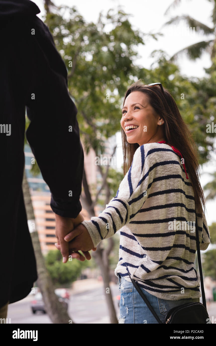 Couple holding hands on sidewalk in the city Stock Photo - Alamy