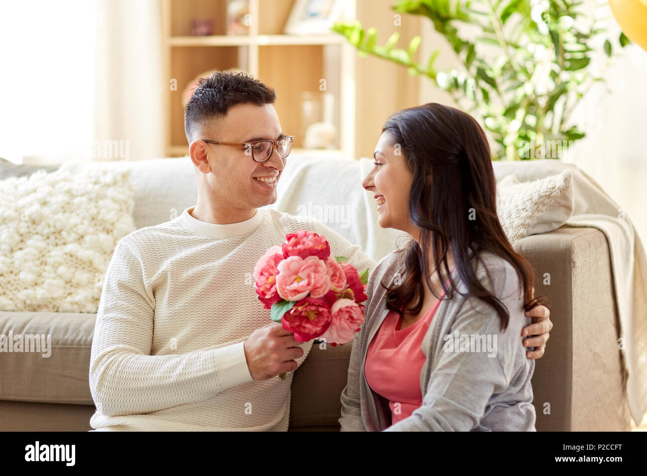 happy husband giving flowers to his wife at home Stock Photo Alamy