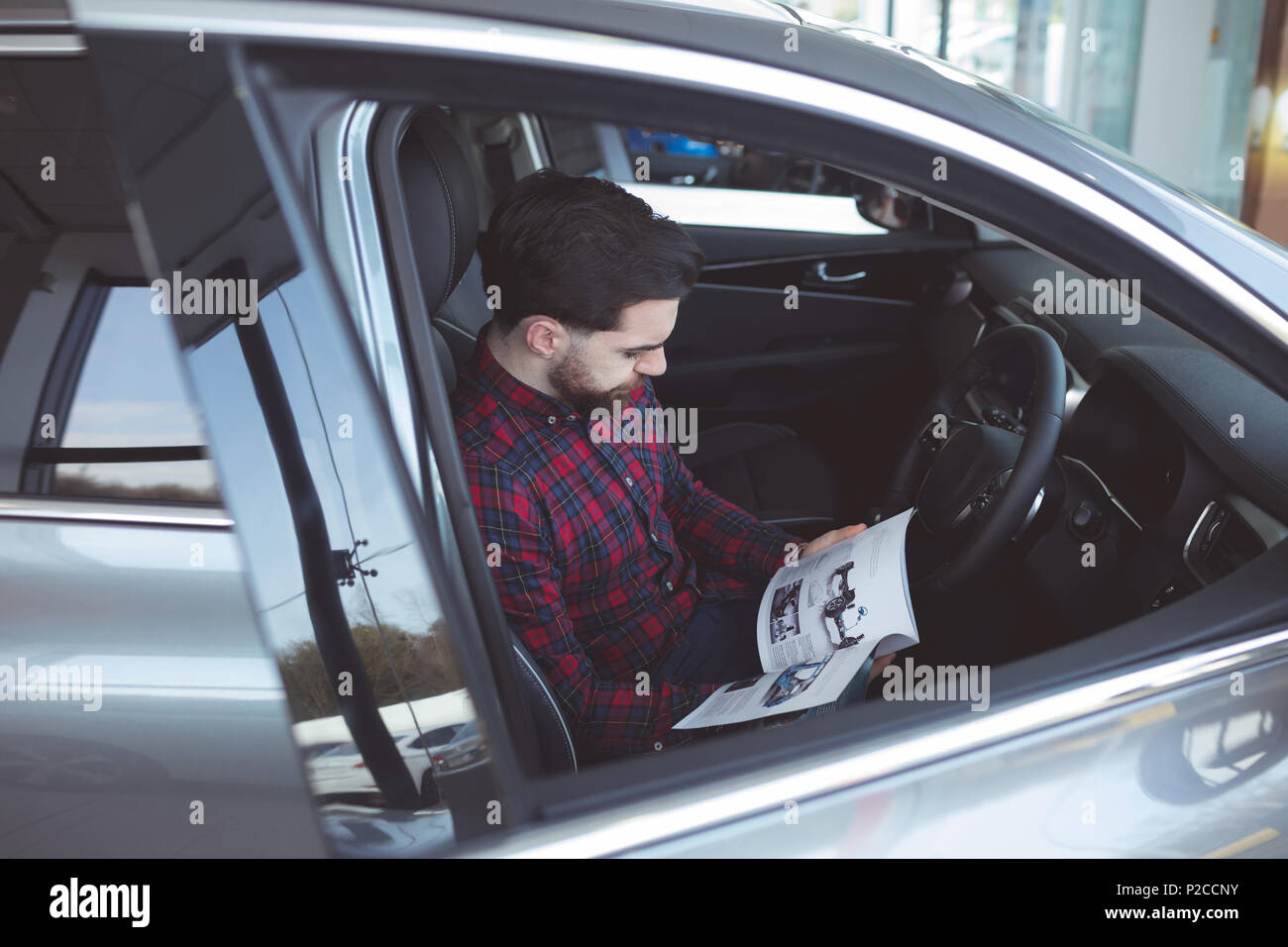 Salesman reading brochure inside the car Stock Photo