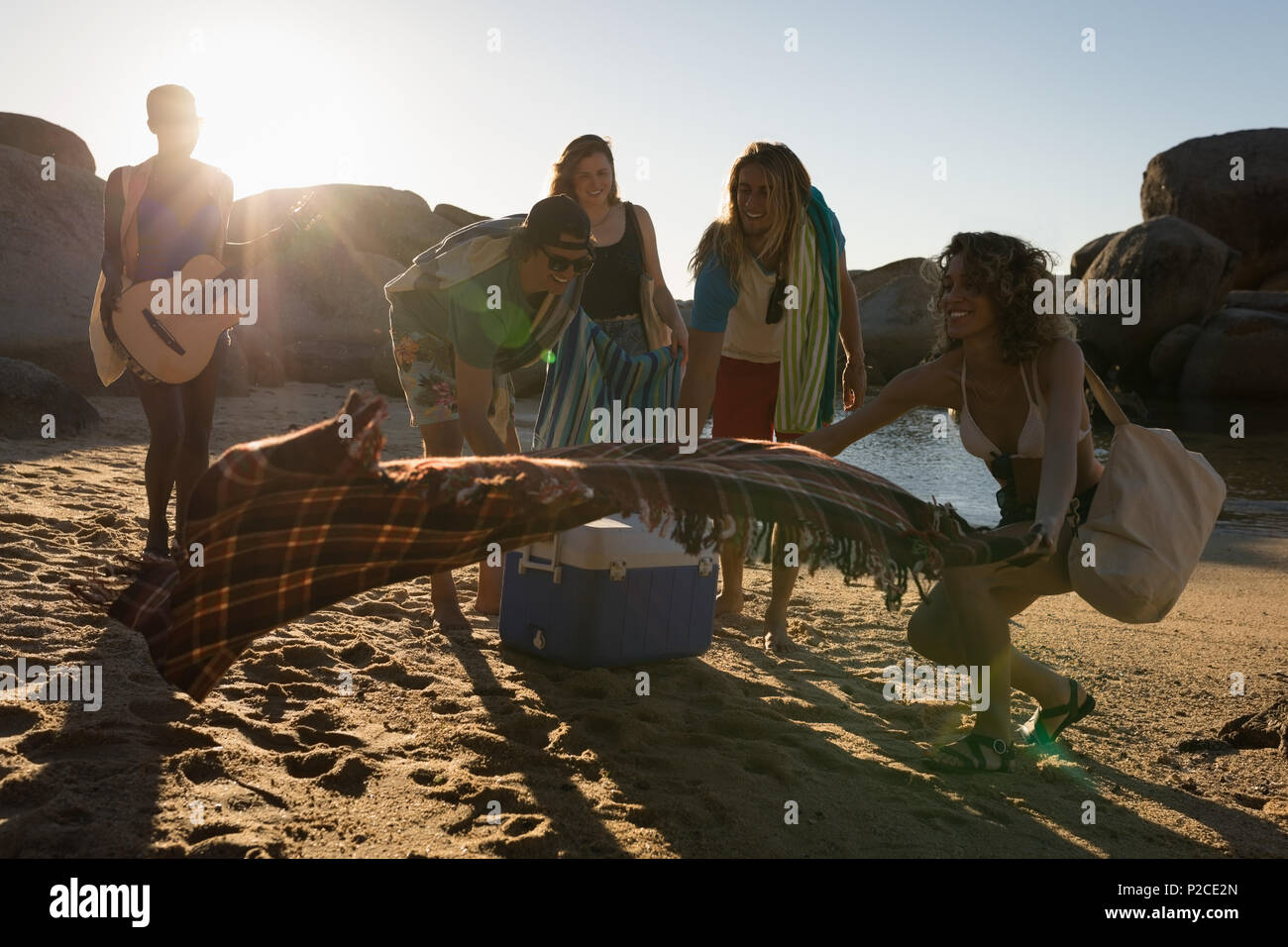 Group of friends laying down picnic blanket Stock Photo