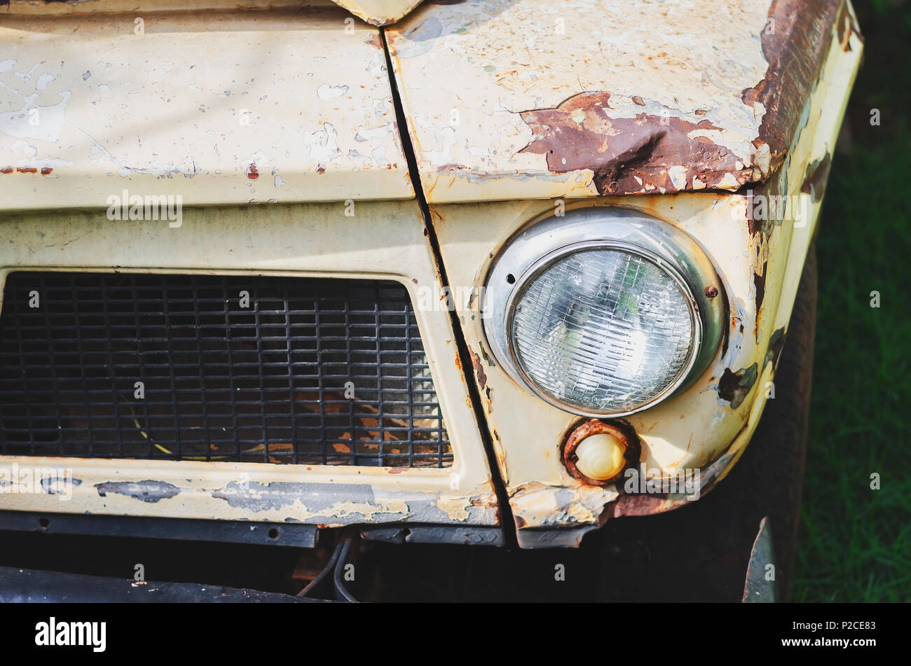 Close up on the headlight of a old pickup truck with a rusty bumper and