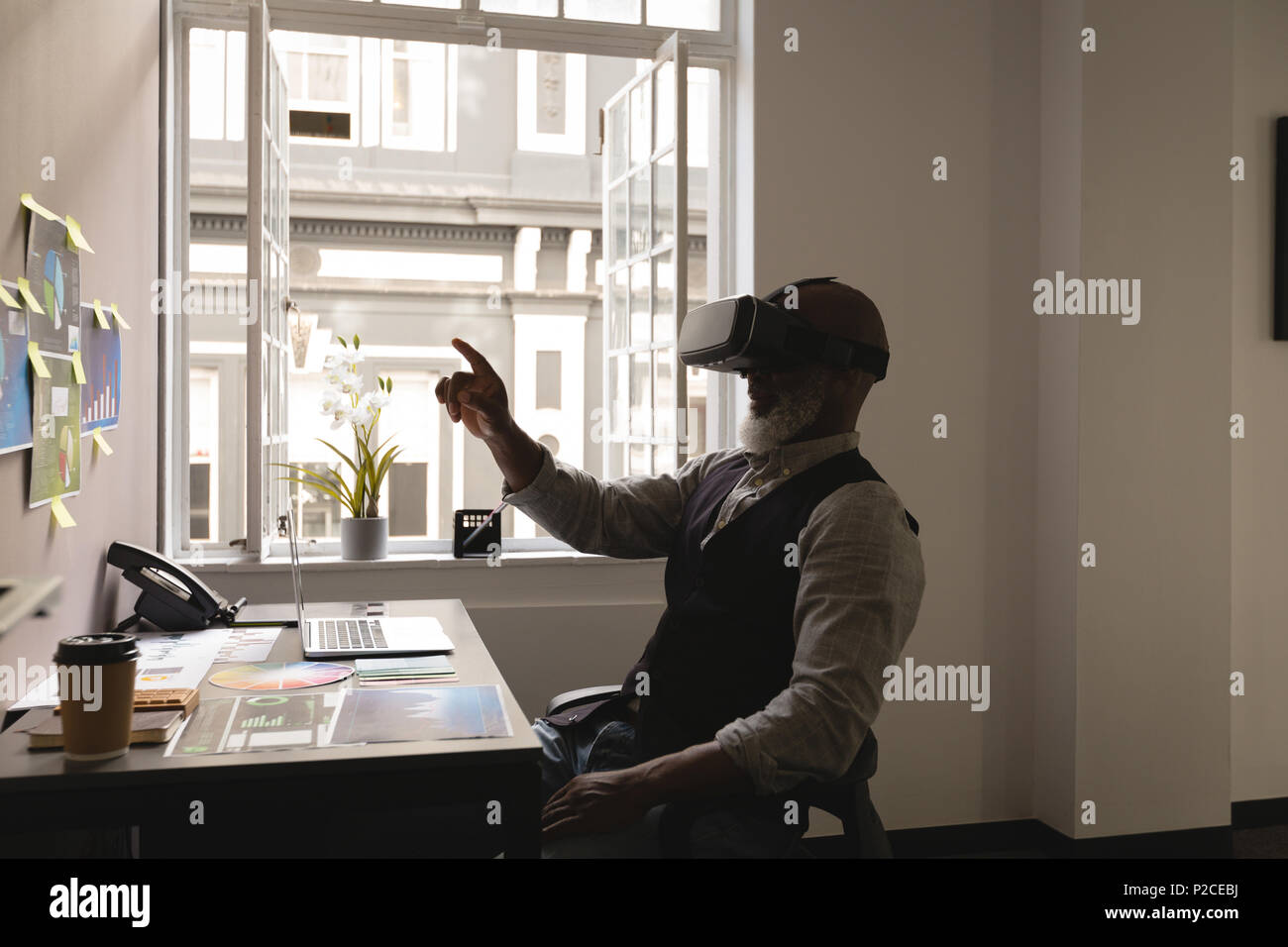 Senior graphic designer using virtual reality headset Stock Photo