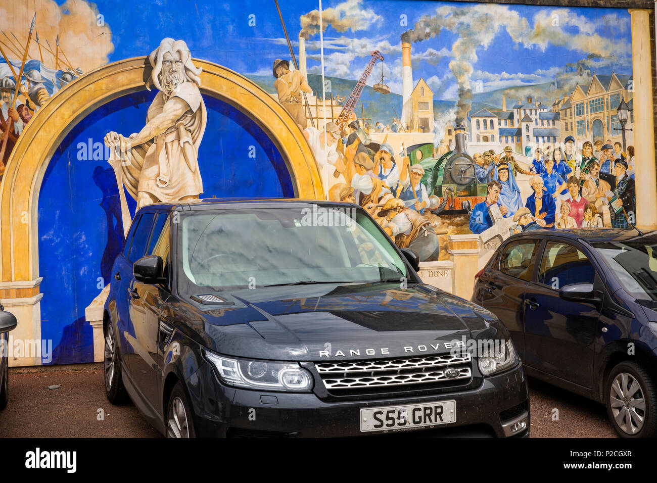 UK, Cornwall, Liskeard, Pigmeadow Lane, local history mural and parked cars Stock Photo