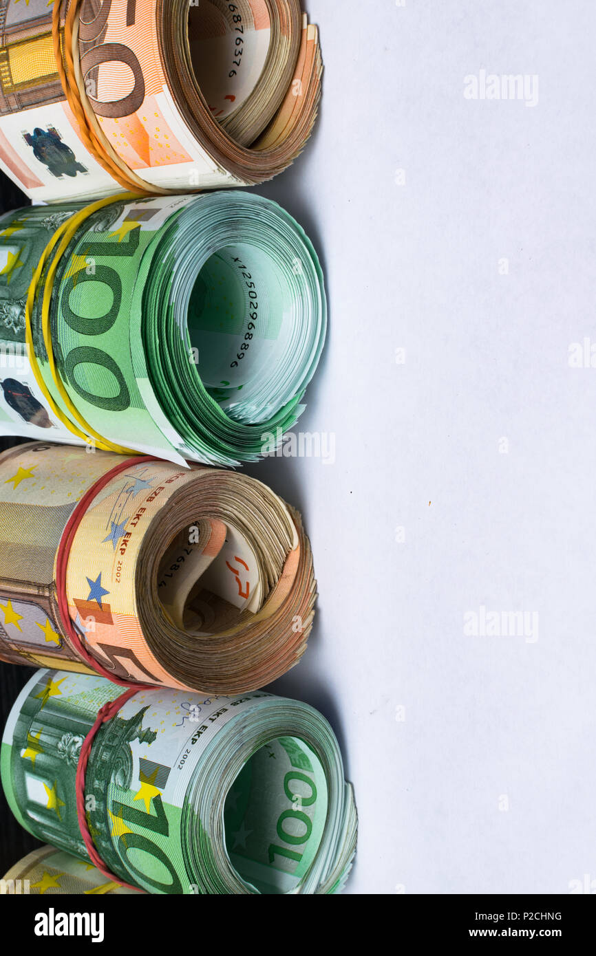 Rolled several thousand euro banknotes with rubbers background. Euro ...