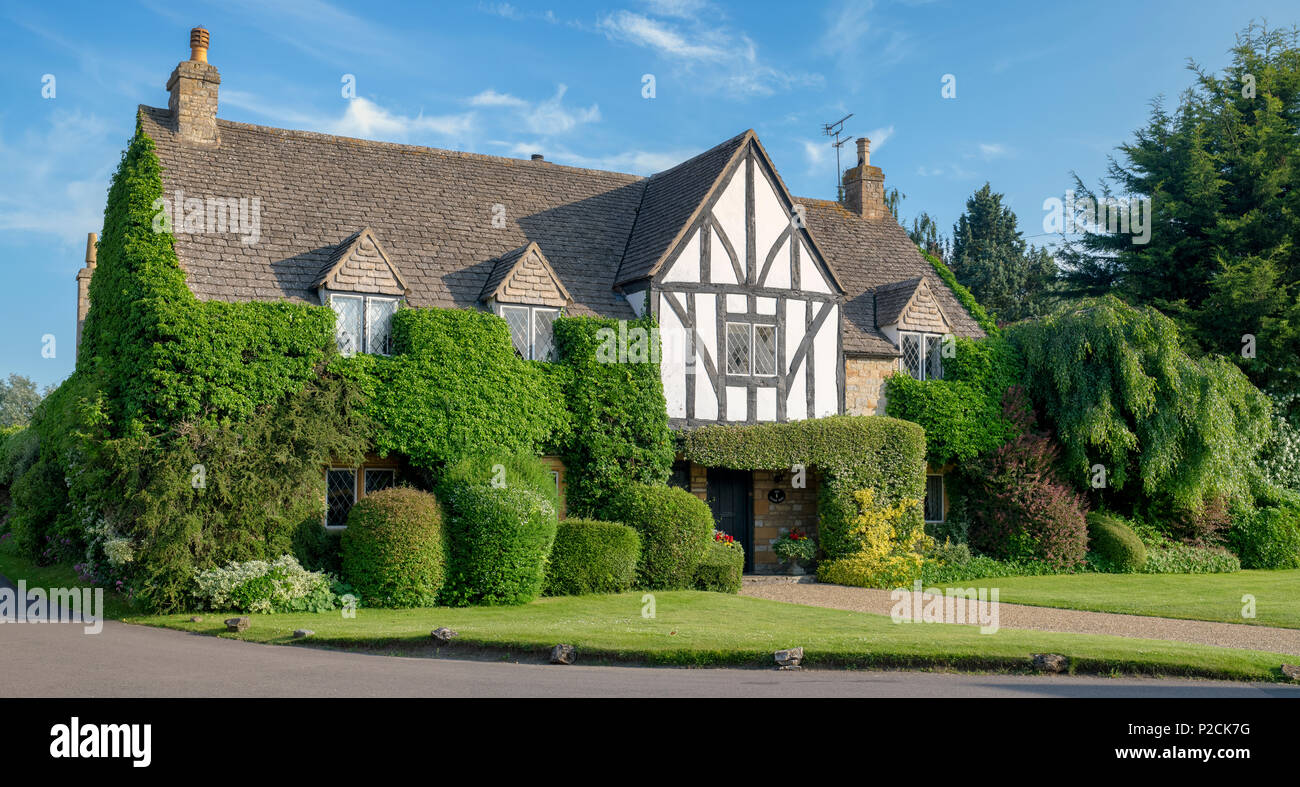 Large house covered by foliage in the village of Tredington, Warwickshire, England. Panoramic Stock Photo