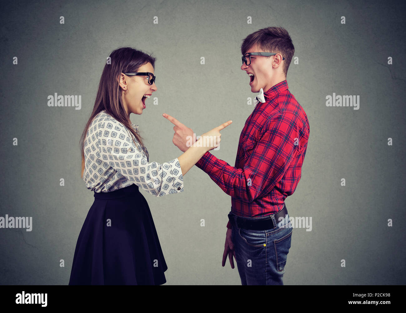Side view of young man and woman accusing each other and screaming having problems. Stock Photo