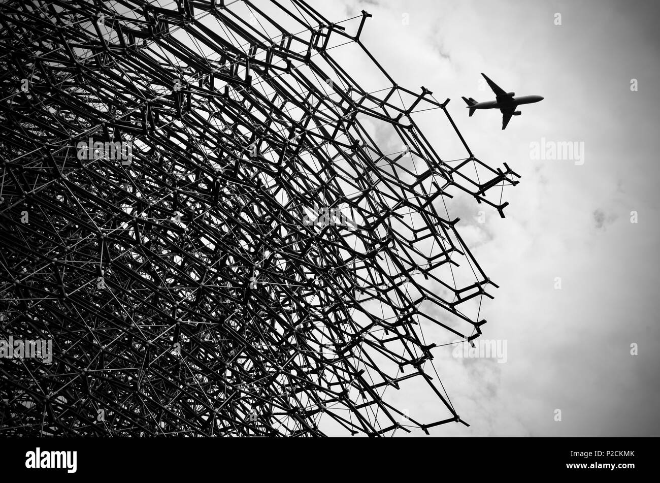 Jet airliner approaching Heathrow Airport passing over 'The Hive' at Kew Gardens, England. Stock Photo
