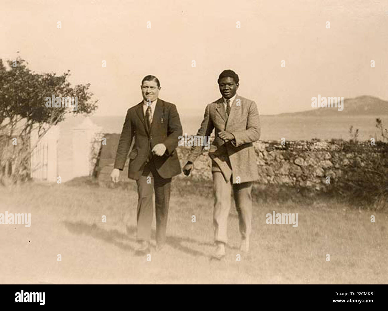 . This is Battling Siki from Senegal, World Light Heavyweight Boxing Champion, with his sparring partner, Frenchman Eugene Stuber. Siki was in Dublin to fight 'Bold' Mike McTigue (aka 'Methuselah') who hailed from Kilnamona, Co. Clare. The two men are pictured outside the Claremont Hotel, Howth, Co. Dublin. The fight was on Saturday, 17 March 1923 (St. Patrick's Day) at La Scala Theatre, Dublin. McTigue won on points. Irish Times reporting on Monday 19 March was a little sniffy about the quality of the boxing: 'There was an almost total absence of those thrills and exciting incidents one is wo Stock Photo