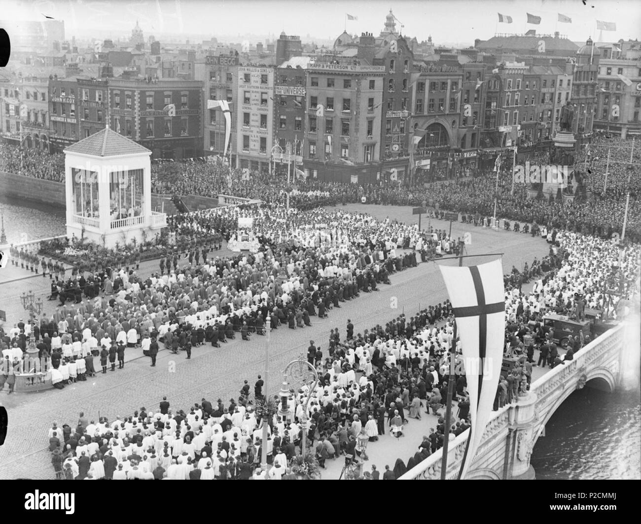 . This amazing scene is the closing ceremony of the Eucharistic Congress that was held in Dublin in June 1932. Earlier in the day, there had been a Solemn Pontifical High Mass at 1 p.m. in the Phoenix Park, with a special choir of 500 men and boys. A procession estimated at one million people, described as 'miles of praying people', then made its way to O'Connell Bridge. The Service of Benediction and Hymns on O'Connell Bridge took place around 5.30 p.m., and the Papal Legate Cardinal Lorenzo Lauri gave his final address of the Eucharistic Congress from this location. Date: Sunday, 26 June 193 Stock Photo