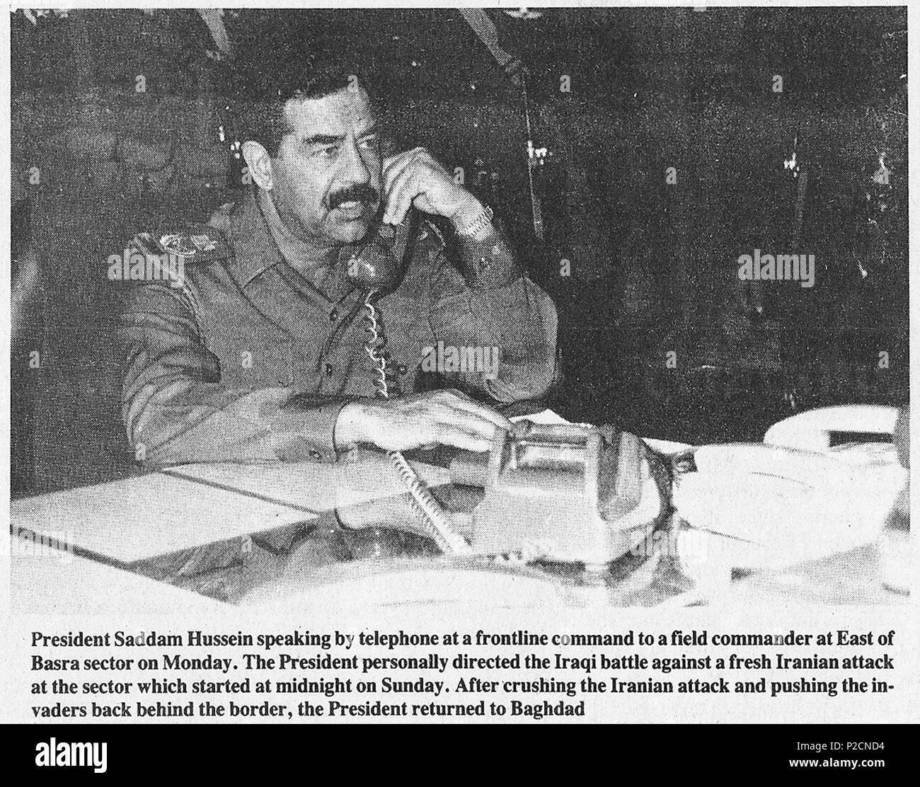 . English: Iraqi president and Field marshal Saddam Hussein speaking by telephone at a frontline command to a field commander at East of Basra sector on Monday, June 13th. The president personally directed the Iraqi battle against a fresh Iranian attack at the sector which started on Sunday, June 12th. 13 June 1988. Iraqi News Agency 50 Saddam Hussein on a telephone call, 1988 Stock Photo