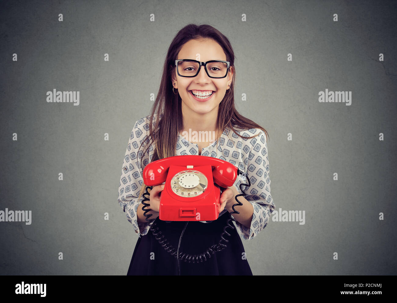 Cute happy woman with retro style red telephone Stock Photo