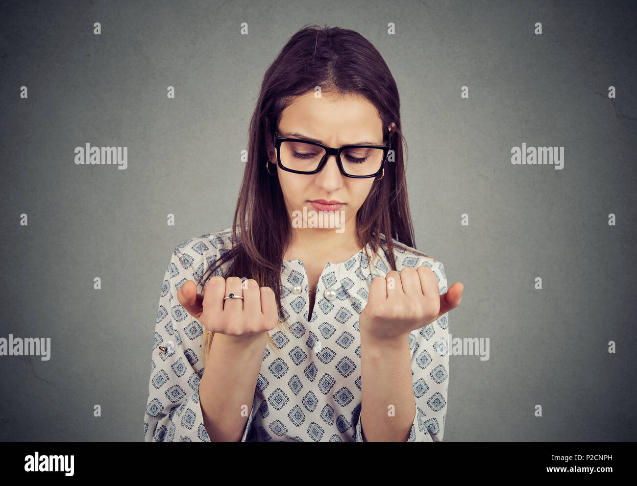 Perfectionist young woman looking at fingers nails obsessing about cleanliness Stock Photo