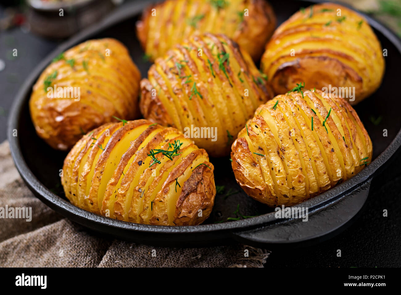 Baked potato with herbs on black background. Vegan food. Healthy meal