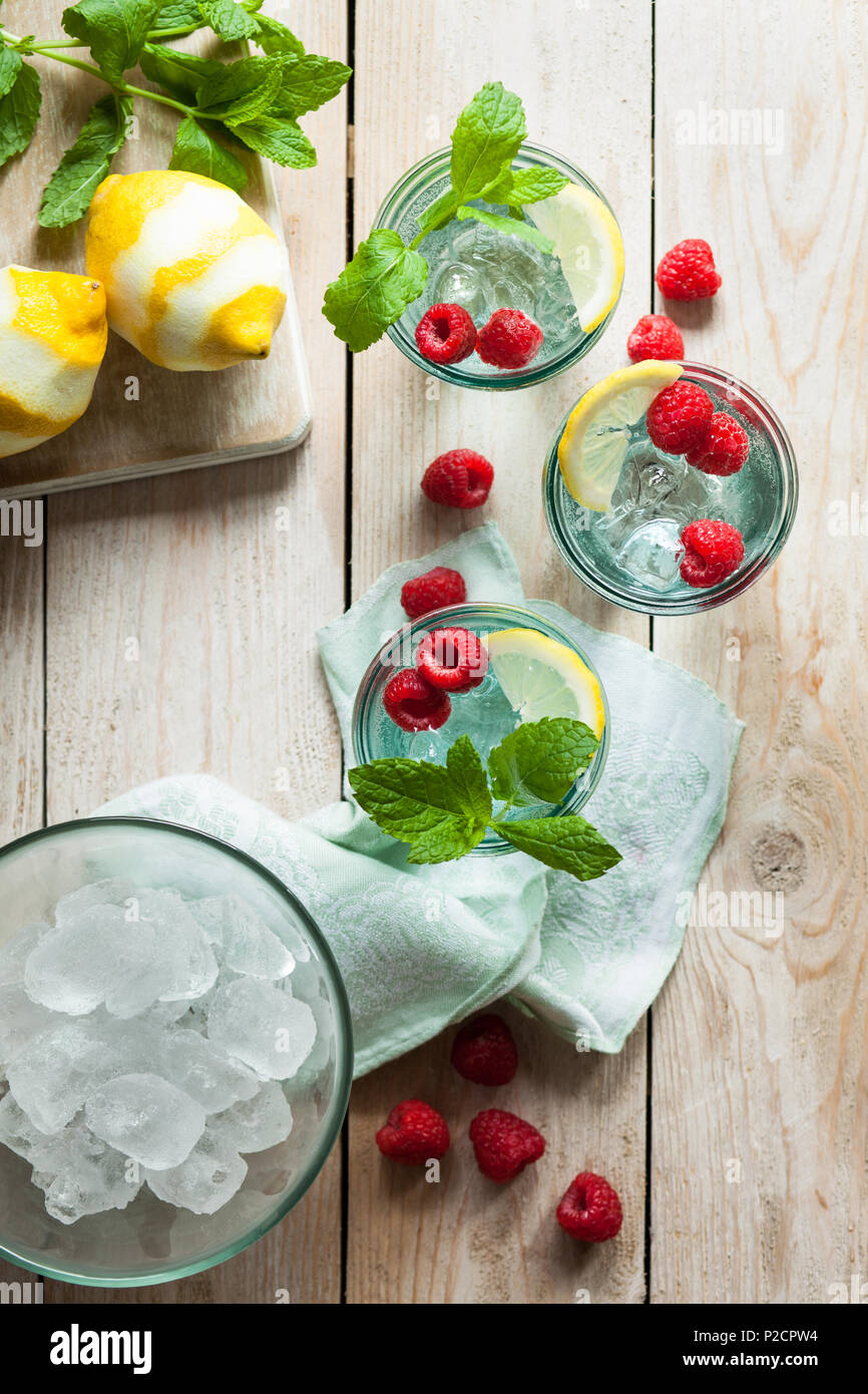 Refreshing iced summer drinks garnished with fresh fruit and mint Stock Photo