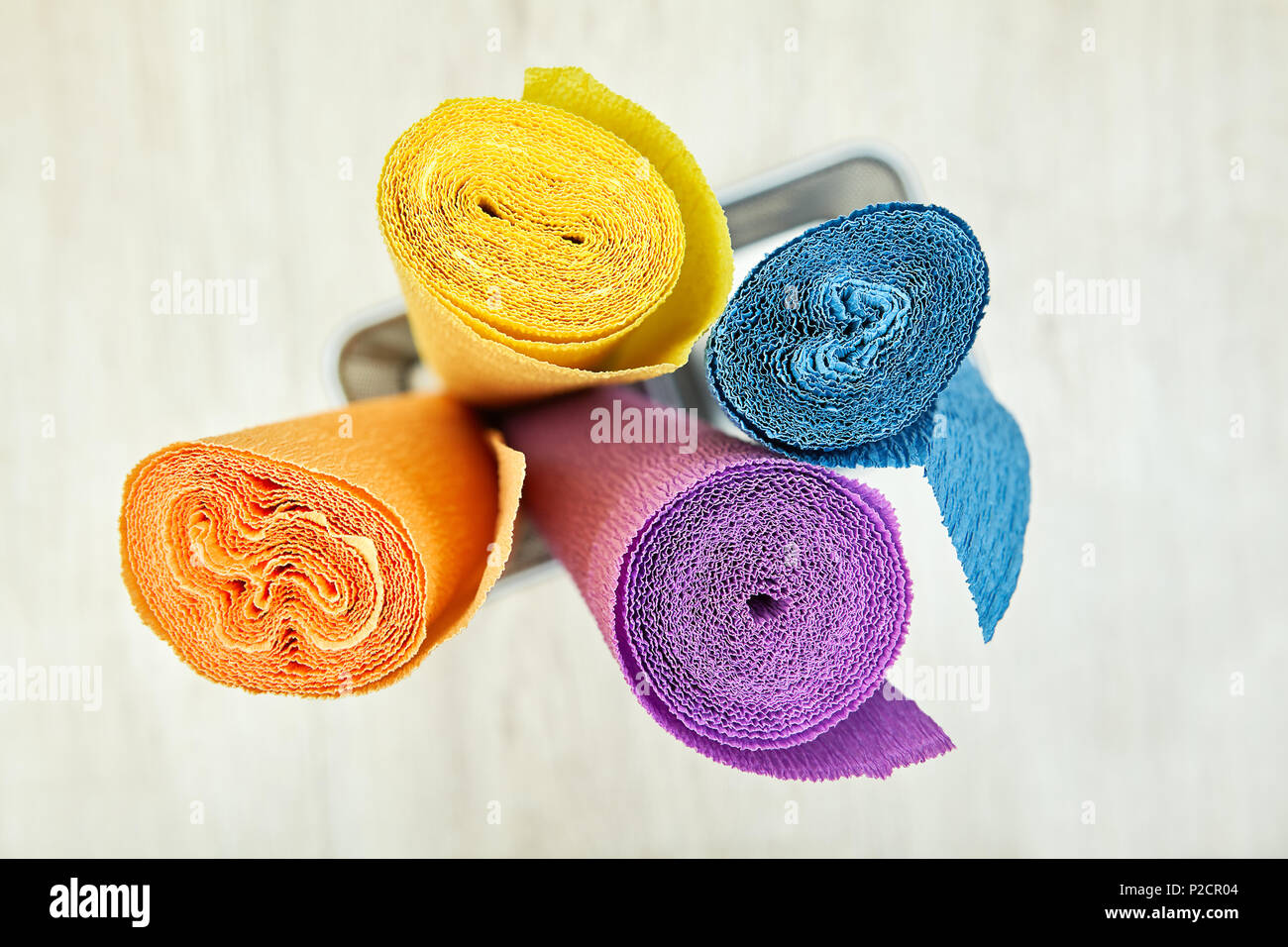 Corrugated wrapping paper is twisted into four colored rolls. Stock Photo