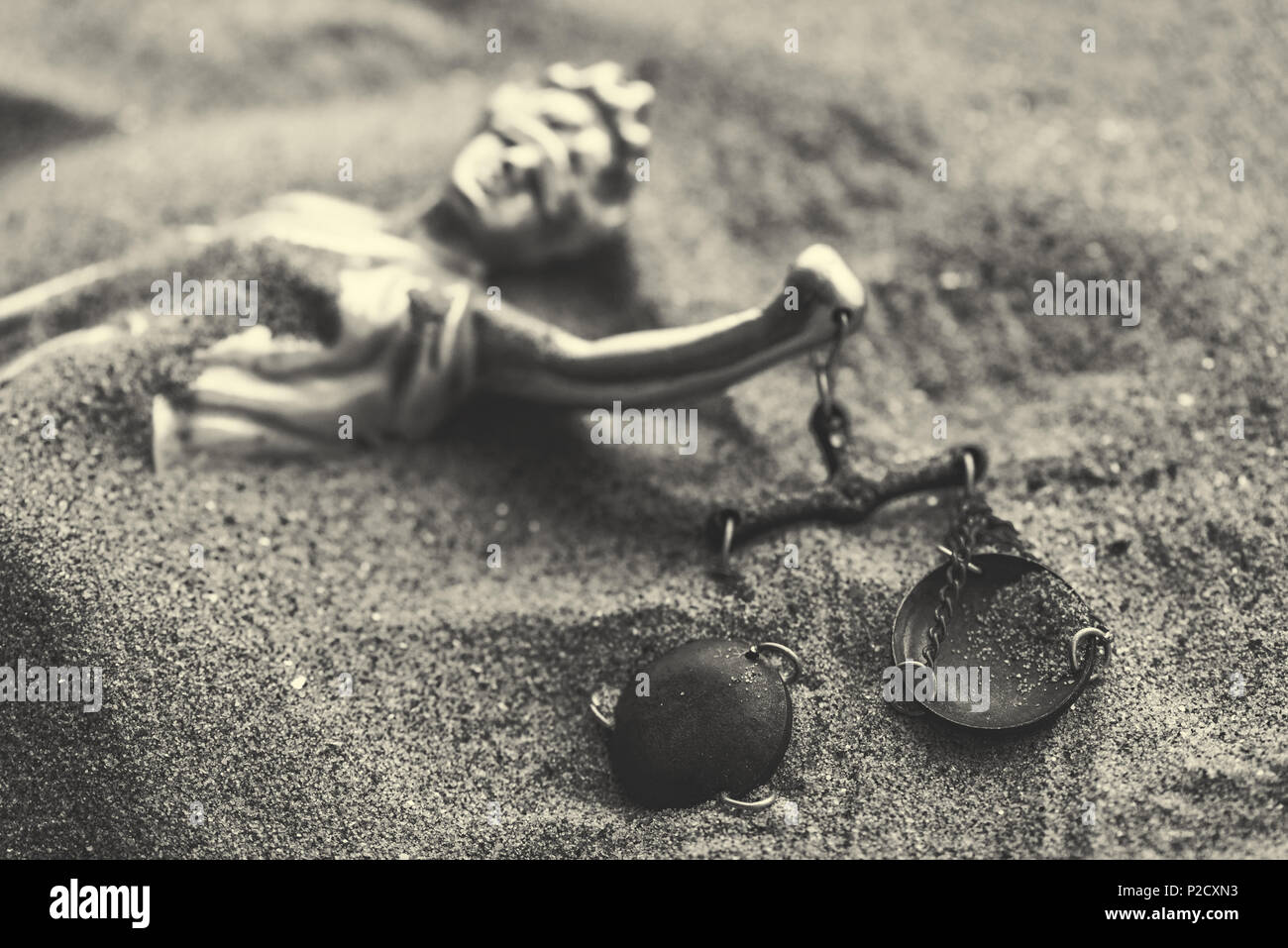 Statue of lady Justice with scale buried in sand, concept of unsolved cold case crime Stock Photo