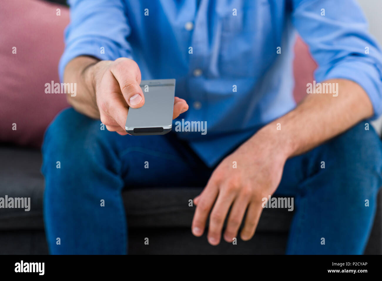 cropped shot of man changing channels while watching tv at home Stock Photo