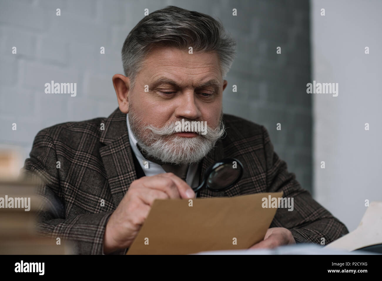 senior writer reading manuscript with magnifying glass Stock Photo - Alamy