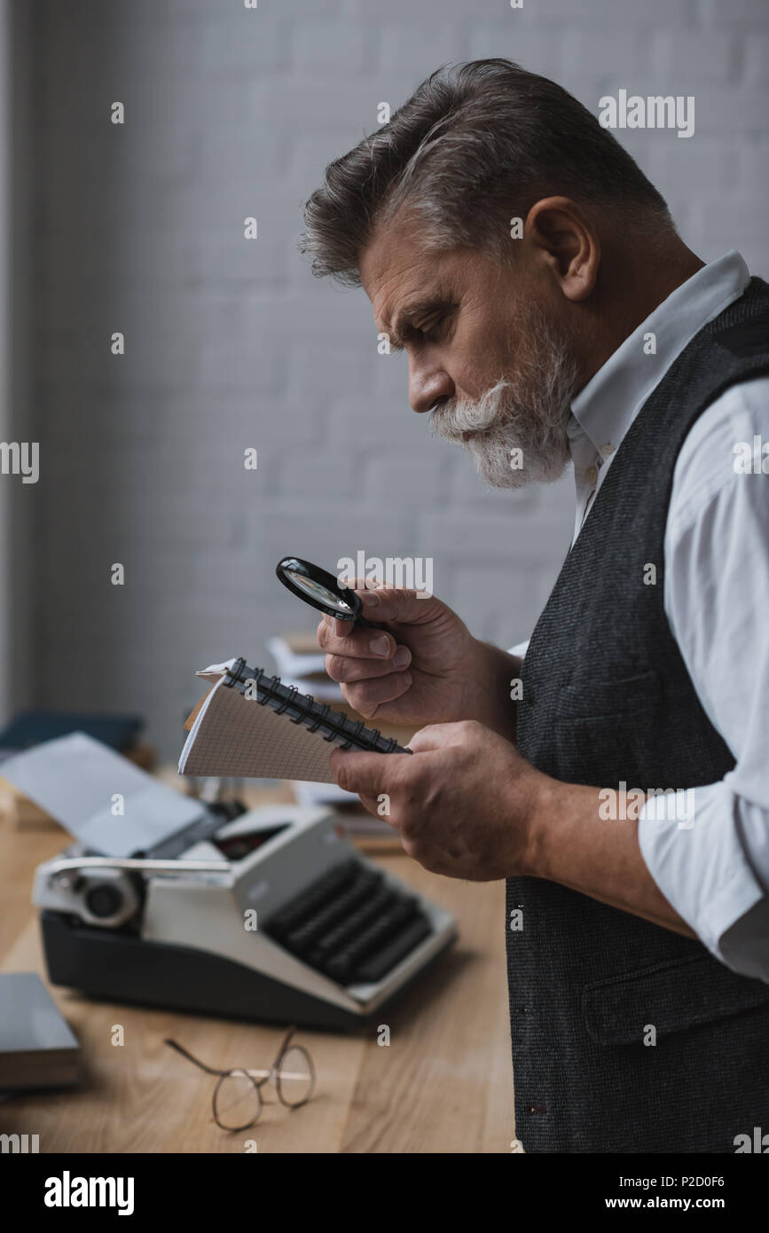 senior writer reading manuscript with magnifying glass Stock Photo - Alamy