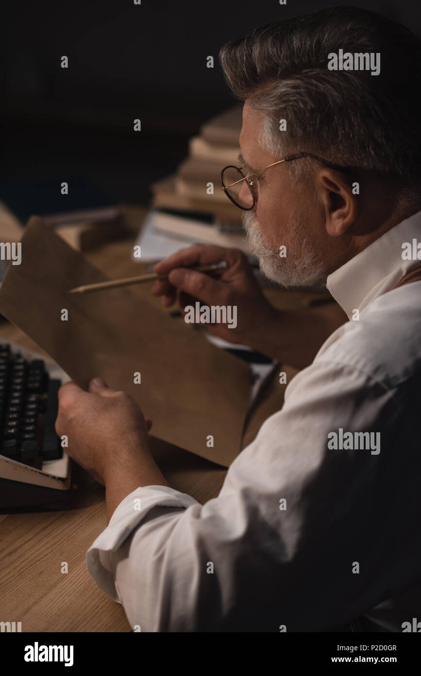 concentrated senior writer working with manuscript Stock Photo - Alamy
