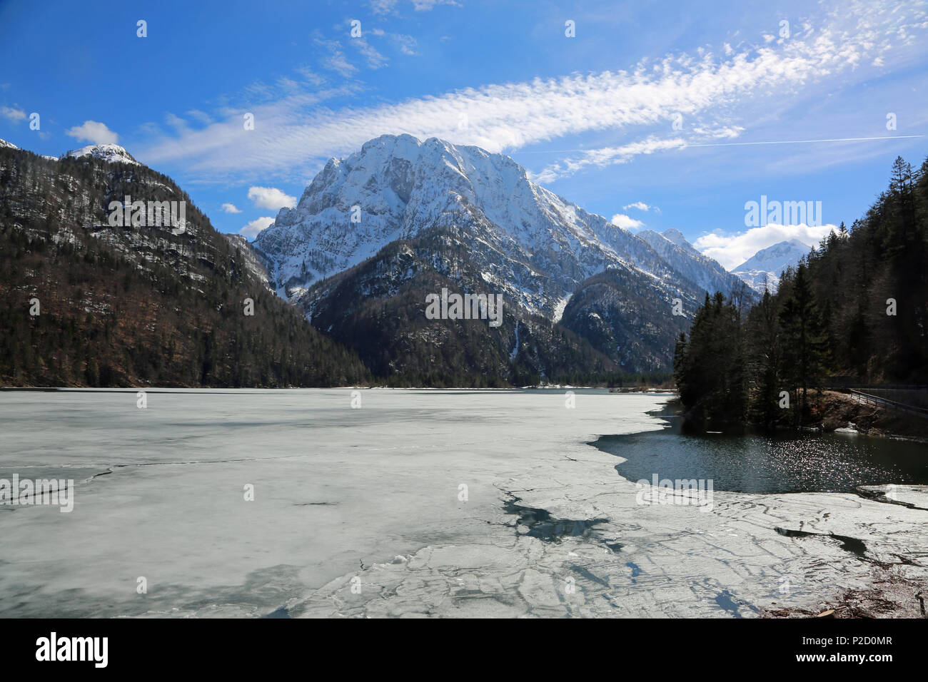 iced alpine lake called Lago del Predil in Italy near Tarvisio Town and mountains in winter Stock Photo